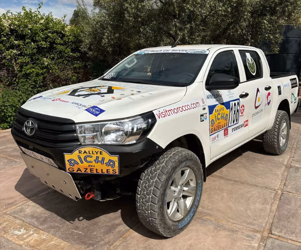 Toyota Hilux double cabine équipé pour le Rallye Aïcha des Gazelles avec plaque de protection et stickers rallye